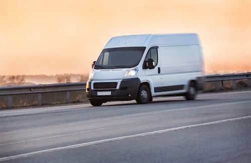 Vrachtwagen rijdt bij zonsopgang over de snelweg.